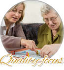 elderly woman and her caregiver playing board game